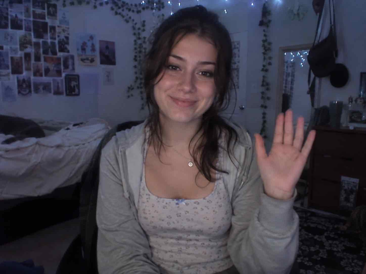 Uma pessoa sorrindo e acenando para a câmera